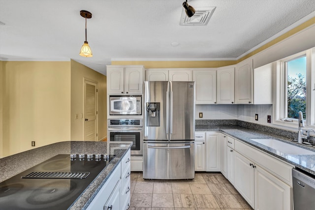 kitchen with appliances with stainless steel finishes, white cabinetry, pendant lighting, and sink