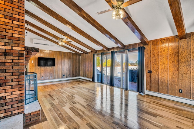 unfurnished living room featuring vaulted ceiling with beams, light hardwood / wood-style floors, a wall mounted AC, and wooden walls