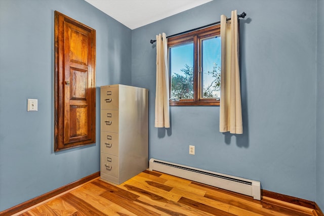 unfurnished room featuring light wood-type flooring and baseboard heating