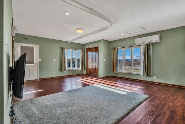 interior space featuring a wall mounted AC, dark hardwood / wood-style flooring, and plenty of natural light