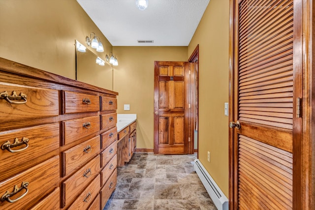 bathroom featuring a textured ceiling, vanity, and baseboard heating