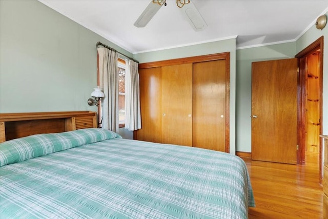 bedroom featuring light hardwood / wood-style floors, a closet, crown molding, and ceiling fan