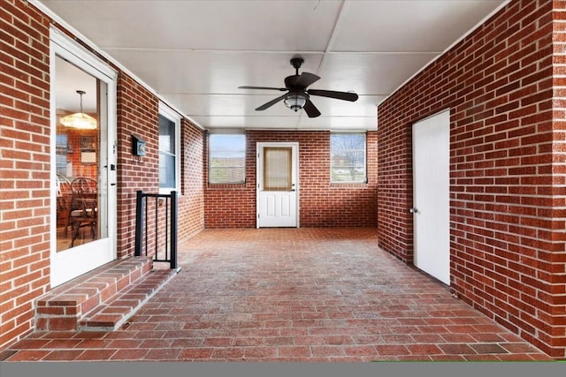 unfurnished sunroom featuring ceiling fan