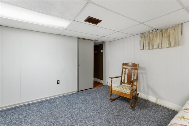 unfurnished room featuring a paneled ceiling and carpet floors