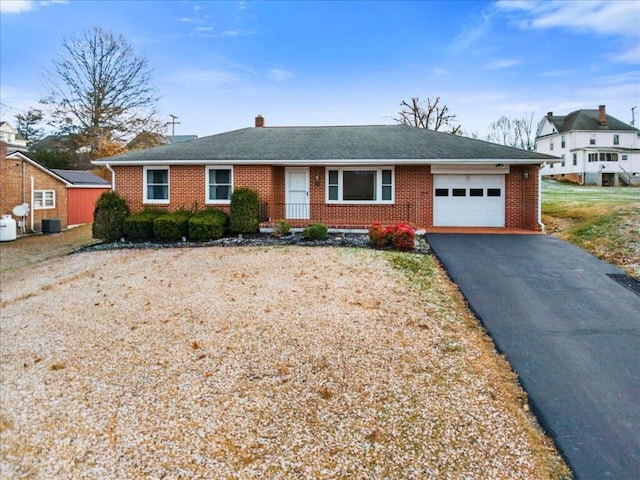 ranch-style house with central AC unit and a garage