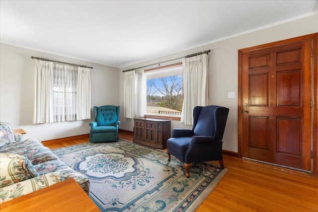 sitting room featuring ornamental molding and light hardwood / wood-style flooring