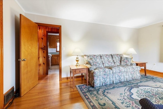 living room featuring ornamental molding and light wood-type flooring