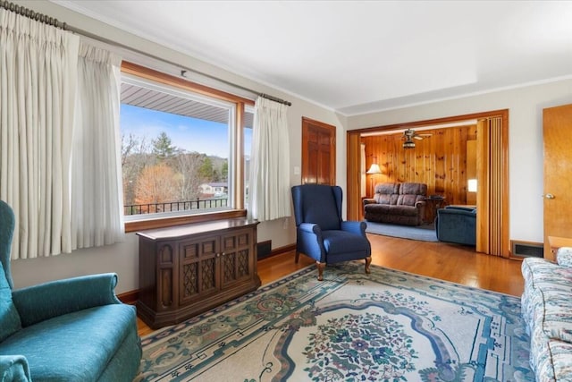 sitting room with hardwood / wood-style floors, ceiling fan, and ornamental molding