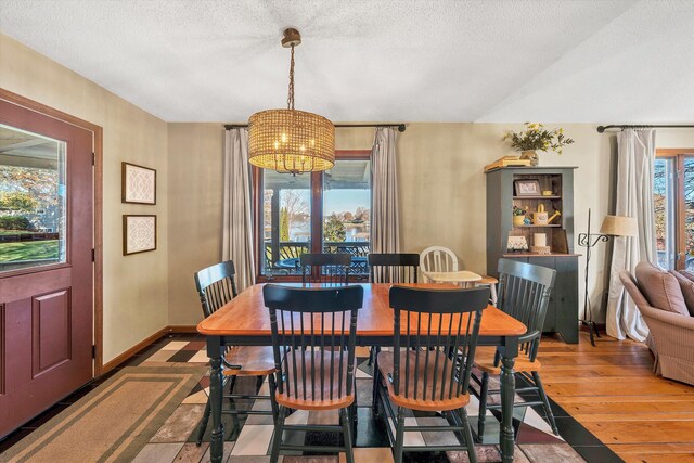 dining area featuring hardwood / wood-style floors, a textured ceiling, and plenty of natural light