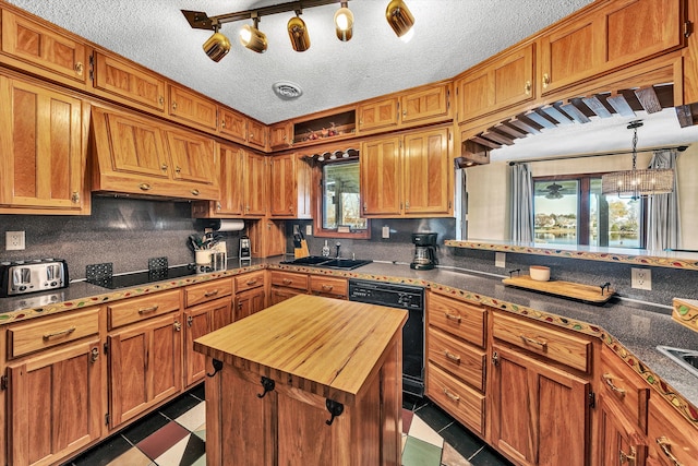 kitchen with black appliances, plenty of natural light, sink, and a textured ceiling