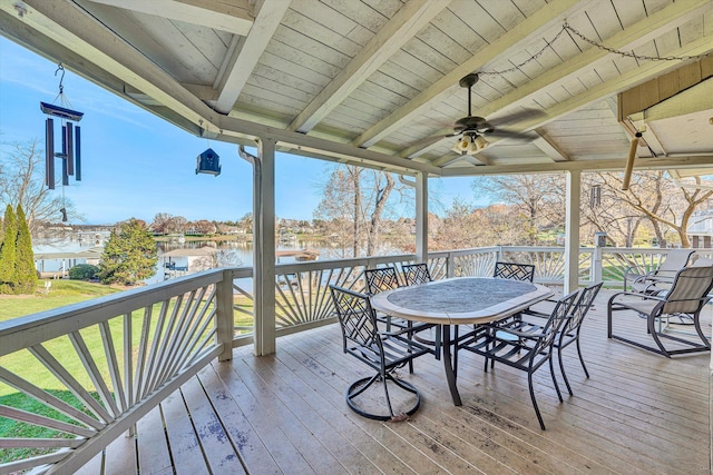 deck featuring ceiling fan, a yard, and a water view