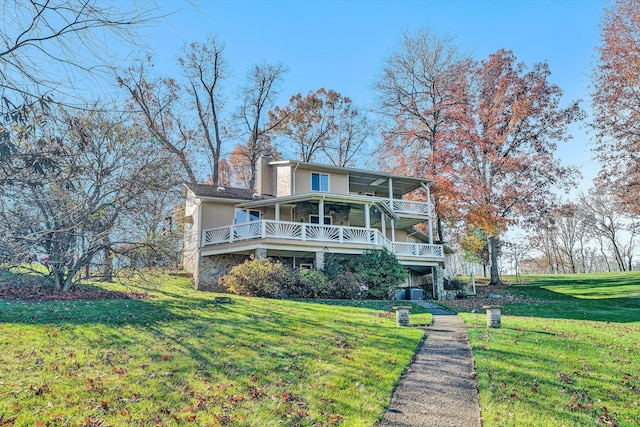 rear view of property featuring a yard and a porch