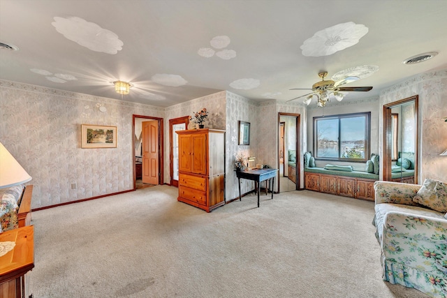 living area featuring light carpet and ceiling fan