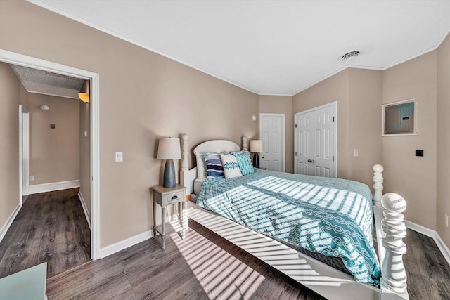 bedroom featuring crown molding, a closet, and dark wood-type flooring