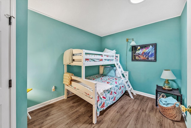 bedroom featuring hardwood / wood-style flooring and crown molding