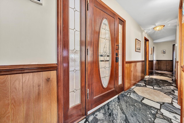 foyer entrance featuring wooden walls