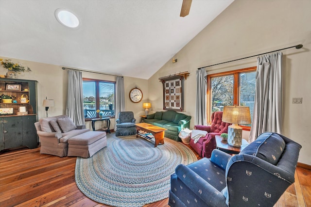 living room with wood-type flooring, high vaulted ceiling, and ceiling fan