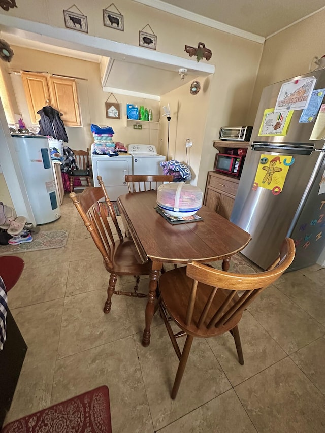 tiled dining area with washing machine and clothes dryer, ornamental molding, and water heater