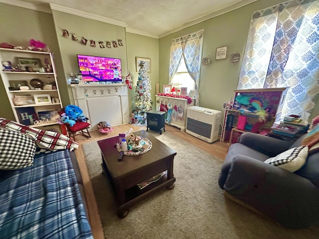 living room with heating unit, hardwood / wood-style flooring, and ornamental molding