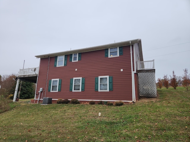 back of property with central AC and a yard