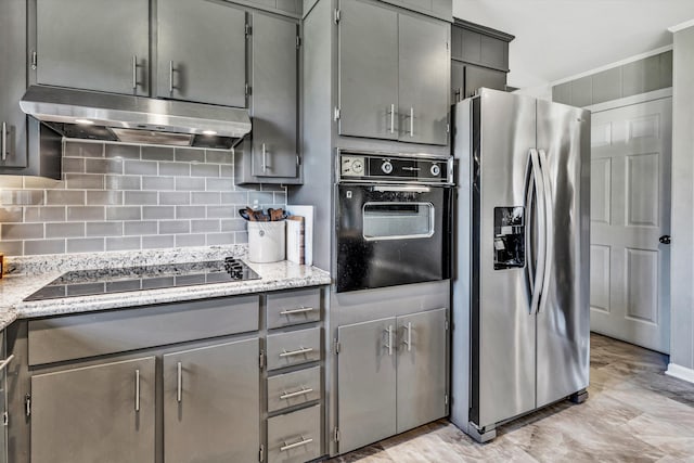 kitchen featuring gray cabinets, decorative backsplash, black appliances, and light stone counters