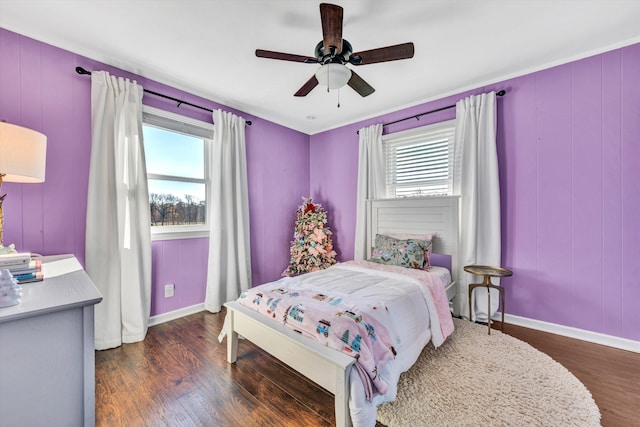 bedroom featuring ceiling fan, dark hardwood / wood-style flooring, and multiple windows