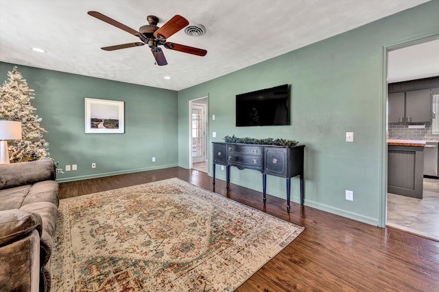 living room with ceiling fan and dark hardwood / wood-style floors