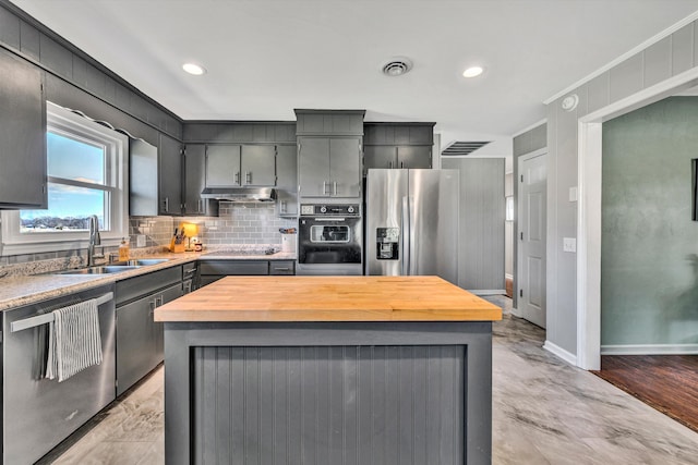 kitchen featuring a center island, light hardwood / wood-style flooring, crown molding, and black appliances