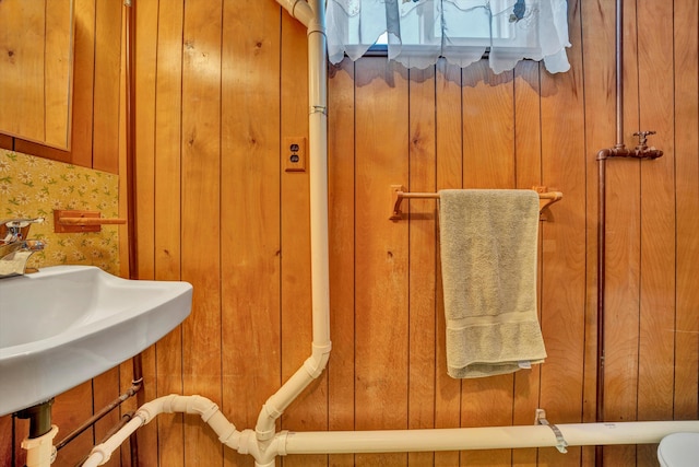 bathroom with wood walls and sink