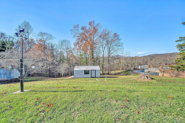 view of yard with a mountain view, a rural view, and a shed