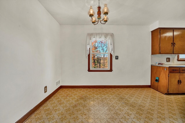 unfurnished dining area with a chandelier