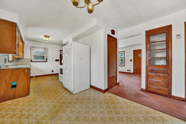 kitchen with light carpet and white appliances