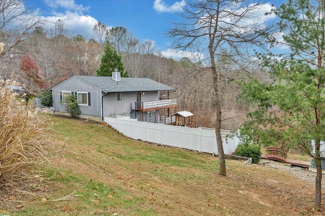 back of house with fence and a lawn