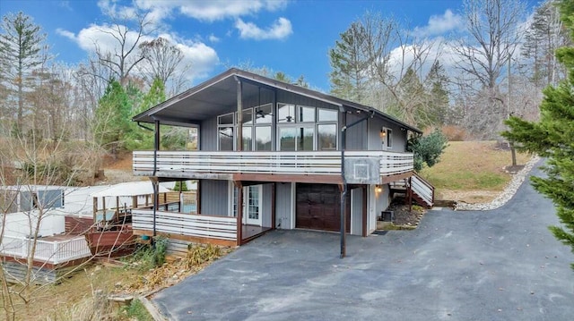 view of front facade featuring aphalt driveway, stairway, and an attached garage