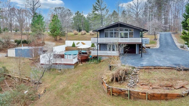 rear view of property with driveway and a deck