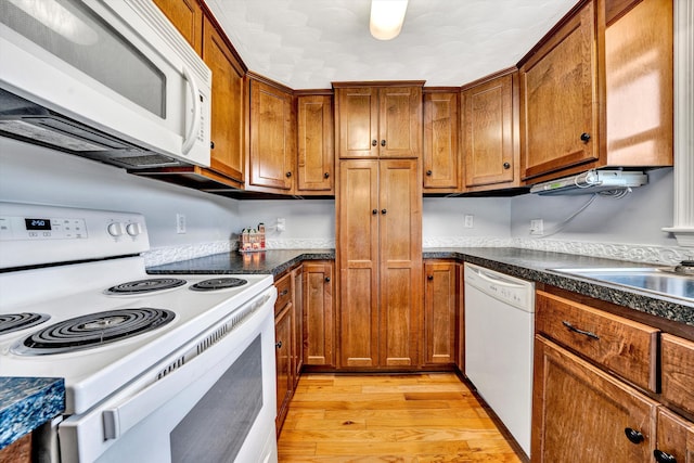 kitchen featuring white appliances and light hardwood / wood-style floors