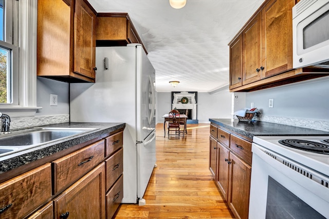 kitchen featuring white appliances, sink, and light hardwood / wood-style flooring