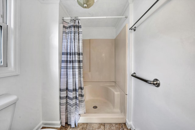 bathroom with curtained shower, crown molding, and toilet