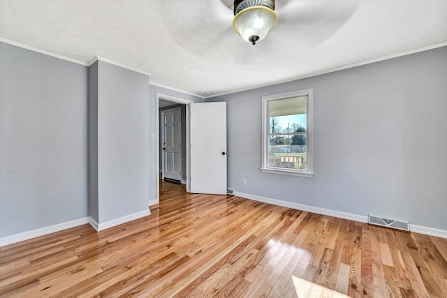 spare room featuring light hardwood / wood-style floors and ornamental molding