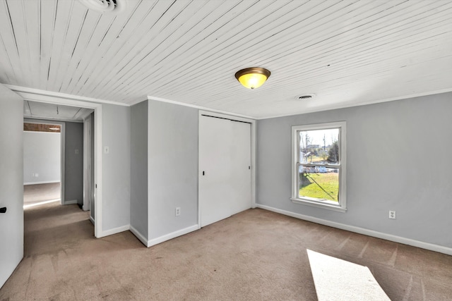unfurnished bedroom featuring carpet, wooden ceiling, and a closet