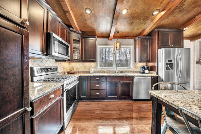 kitchen featuring appliances with stainless steel finishes, dark hardwood / wood-style flooring, sink, beamed ceiling, and hanging light fixtures