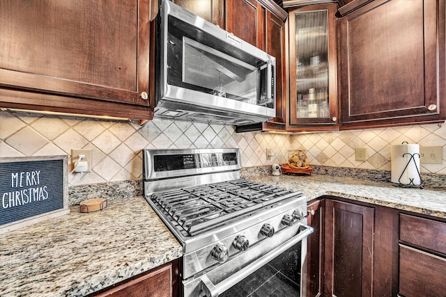 kitchen featuring tasteful backsplash, light stone counters, and stainless steel appliances