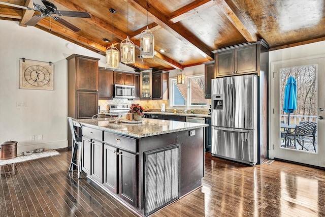 kitchen featuring appliances with stainless steel finishes, a center island, decorative light fixtures, and dark brown cabinets