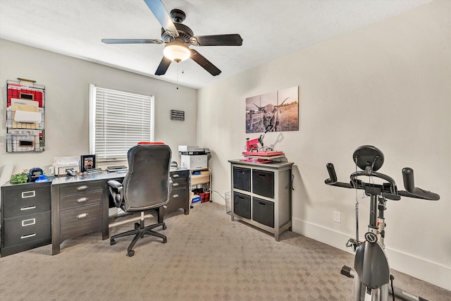 carpeted office with a textured ceiling and ceiling fan