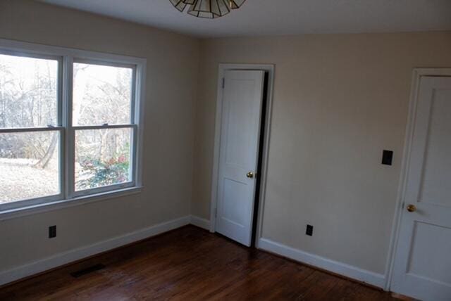 spare room featuring dark wood-type flooring