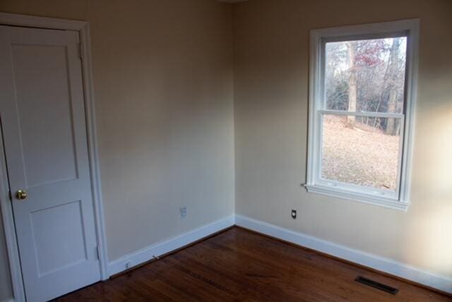 unfurnished room featuring dark wood-type flooring