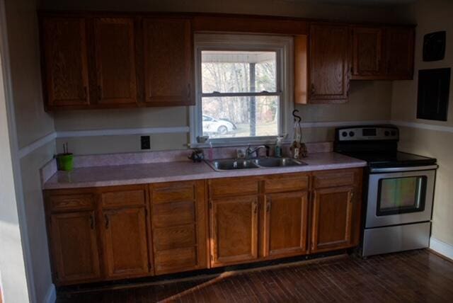 kitchen featuring dark hardwood / wood-style flooring, electric range, and sink