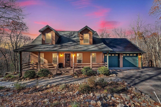 cabin with solar panels, a garage, and covered porch