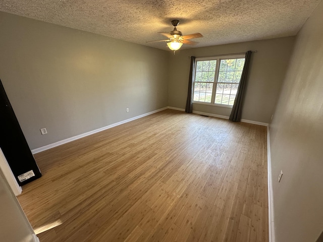 spare room featuring ceiling fan, wood-type flooring, and a textured ceiling