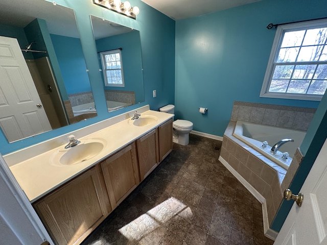 bathroom with vanity, toilet, and tiled tub